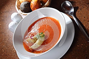 High angle shot of a bowl of red tomato cream soup with croutons