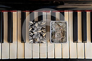 High angle shot of a box with wedding rings on the piano keys