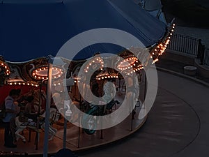 High angle shot of a carousel in an amusement park, illuminated in twilight