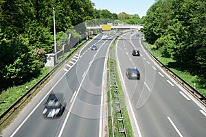 High angle shot of cars driving on a highway surrounded by forests