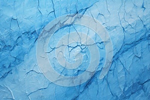 high-angle shot of a cracked glacier, showing deep blue crevasses