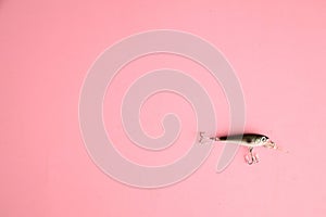 High angle shot of a fishing lure isolated on a pink surface