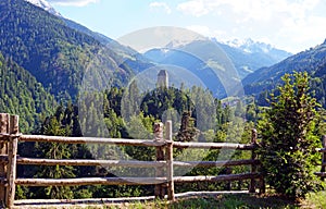 High angle shot of the green forest in the mountains behind the wooden fence