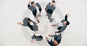 Happy staff aim high. High angle shot of a group of businesspeople raising their hands in triumph in a modern office.