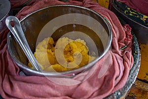 High-angle shot of jaggery and a spoon in a metal plate