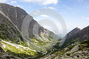 High-angle shot of little Tarpataki valley with sunlight on and blue sky in the background