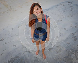 High angle shot model looking directly at camera on beach.
