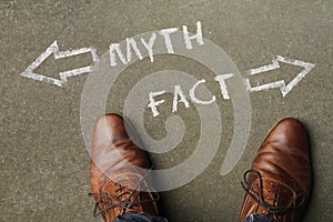 High angle shot of myth and fact marked with opposite directions on the ground photo