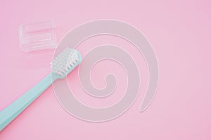 High angle shot of a new toothbrush with a cap isolated on a pink background