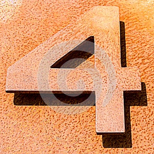 High angle shot of the number 4 on an orange stone surface