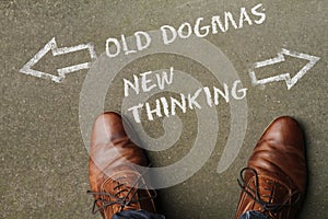 High angle shot of old dogmas and new thinking marked with opposite directions on the ground