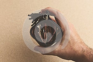 High angle shot of a person holding a leather wallet full of money