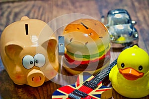 High angle shot of a piggy bank and other kids money bank on a wooden table - savings concept