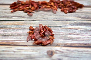 High angle shot of a pile of red chili peppers on a wooden surface