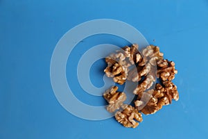 High angle shot of a pile of walnuts isolated on a blue surface