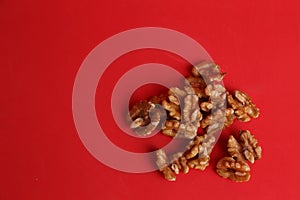 High angle shot of a pile of walnuts on a red surface