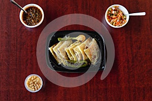 High angle shot of quesadillas in a plastic container with salsas and white beans photo