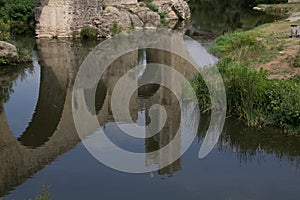High angle shot of the reflection of an old bridge over the river captured in Catalonia, Spain