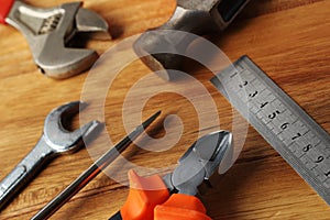 High angle shot of a ruler, a hammer, a screwdriver and other tools on a wooden surface