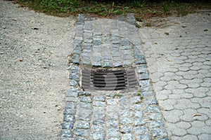 High angle shot of the sewer grate on the sidewalk