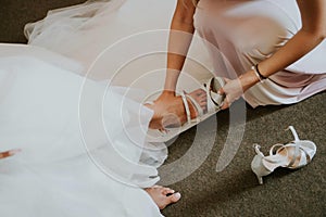 High angle shot of a shemale helping the bride to put on her shoe photo