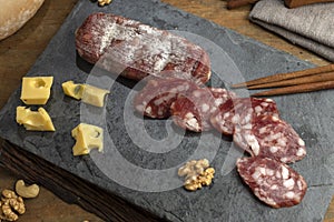 High angle shot of sliced salami and cheese on a board