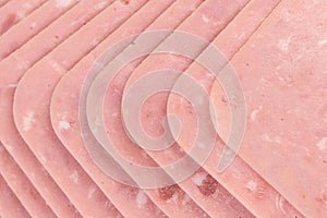 High angle shot of slices of pork lunchmeat lined up in a neat way