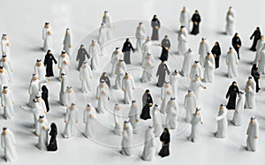 High angle shot of small statues of Muslim people in traditional black and white robes