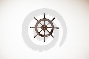 High angle shot of a small wooden ship`s helm on a white surface