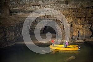High angle shot of tourists in a yellow boat with their tour guide in the Krizna cave, Slovenia