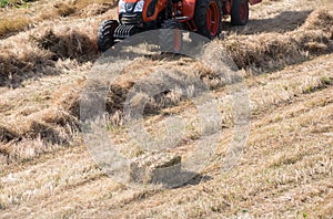 High angle shot of a tractor collecting haystacks in a hayfield