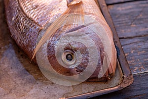 High-angle shot of two â€‹â€‹breams on a tray on a wooden kitchen table