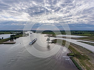 High angle shot of typical dutch landscape with transport ship vessel in a river lek