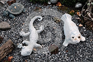 High angle shot of a white lizard and sealion toys on the ground