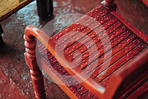 High angle shot of a wooden brown chair with raindrops on it placed outside