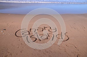 High angle shot of the word canary islands written on the beach sand