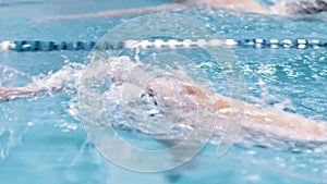 High angle side view man swimming crawl in waterpool slow motion