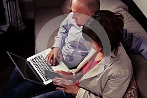 High angle of spouses gazing their gadgets on the couch