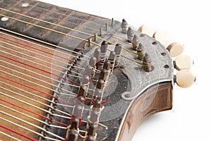 High angle studio shot of vintage, old wooden zither isolated on white background. Detail of zither mechanics and tuning