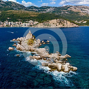 High-angle of Sveta Nedjelja island in an open sea with rocky and forested beach background