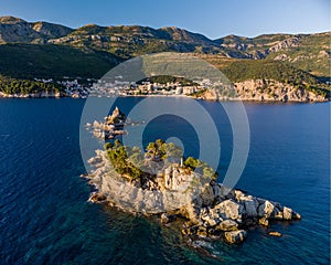 High-angle of Sveta Nedjelja island in an open sea with rocky and forested beach background