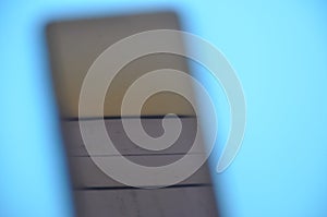 High angle of unique blurred abstract photo of a phone over blue background.