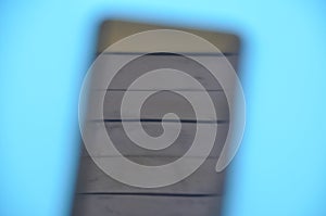 High angle of unique blurred abstract photo of a phone over blue background.