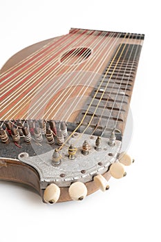 High angle vertical studio shot of vintage, old wooden zither isolated on white background. Detail of zither mechanics