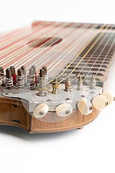 High angle vertical studio shot of vintage, old wooden zither isolated on white background. Detail of zither mechanics