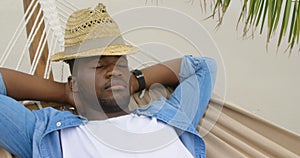High angle view of African american man sleeping in a hammock on the beach 4k