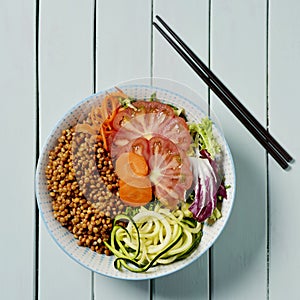 Buddha bowl salad on a pale green table photo