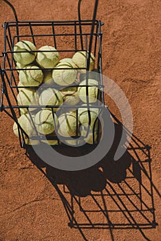 high angle view of basket of tennis balls standing