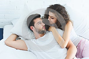 high angle view of beautiful young couple in love lying in bed and looking photo