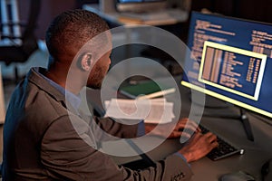 IT developer wearing suit and using computer while working in office